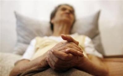 senior woman praying in bed