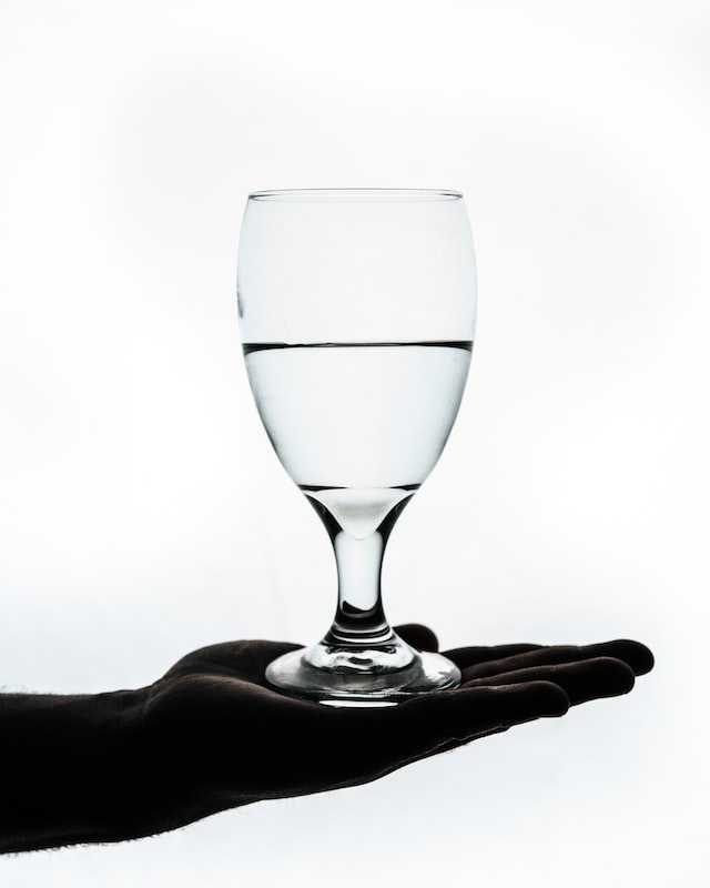 hand holding glass half full